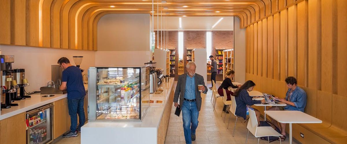 Photograph of the coffee bar at the Williams bookstore with wood panelled ceiling curving down to the wall