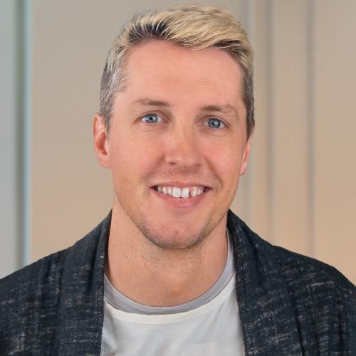 Photo of front profile of Rand Lemley. Grey shirt, black jacket, white background, smile